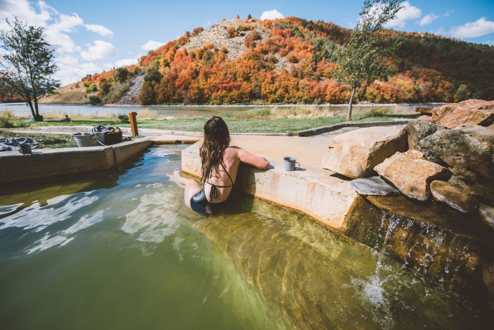Soaking in the hot spring pool by the autumn hillside